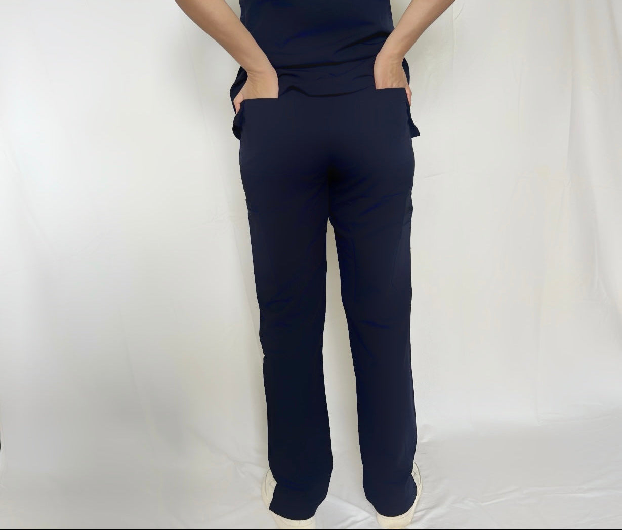 A nurse wearing fitix navy colour scrub pant with two back pocket.