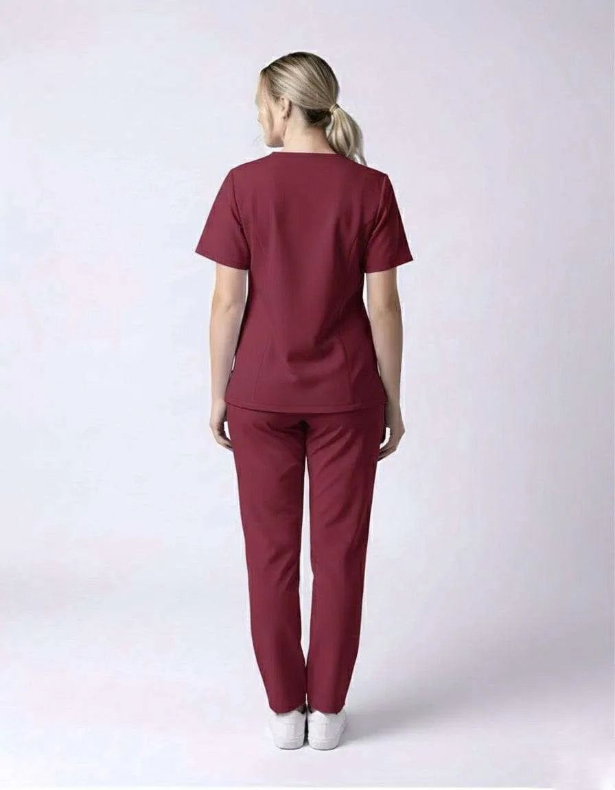 Person wearing a maroon scrub set on a white background
