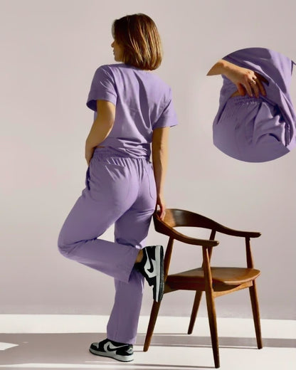 Person wearing a purple outfit with a wooden chair in the background