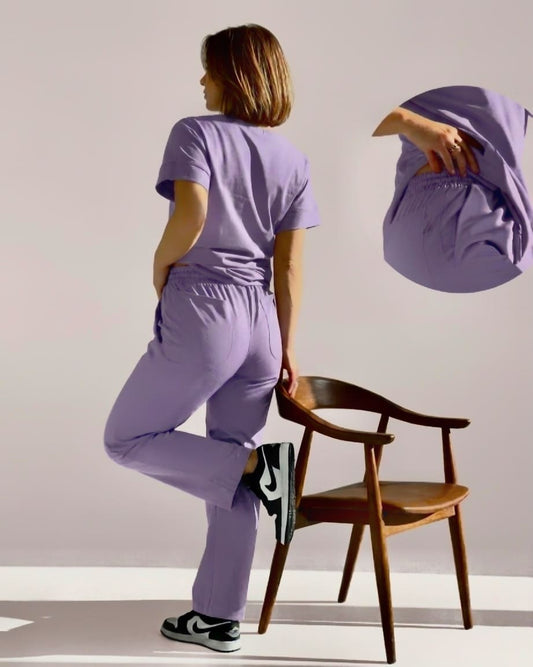 Person wearing a purple outfit with a wooden chair in the background