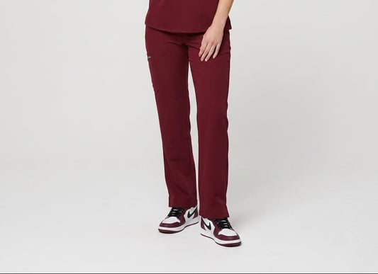 Person wearing a maroon scrub set on a white background