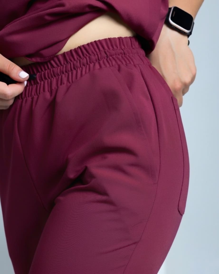 Maroon pants worn by a nurse on a light gray background