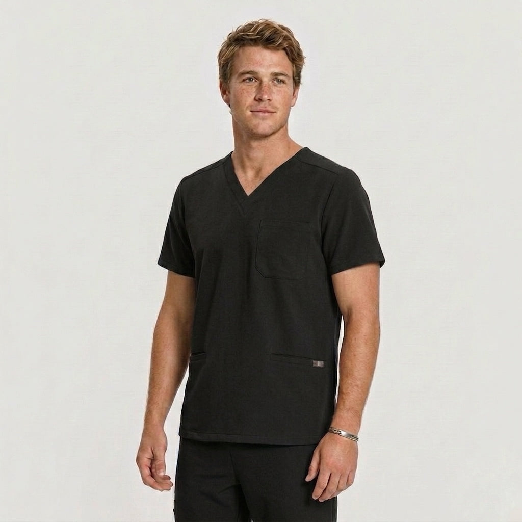 Man wearing a black scrub top against a plain background