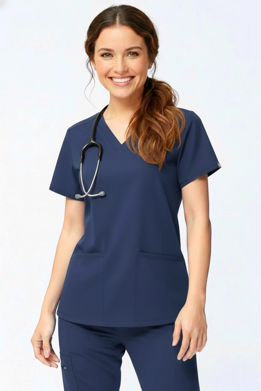 Woman wearing navy blue medical scrubs with a stethoscope on a white background