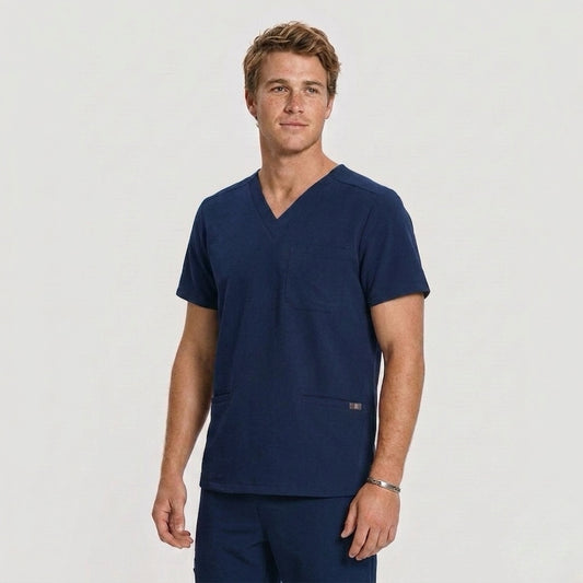 Man wearing a navy blue scrub top on a light gray background