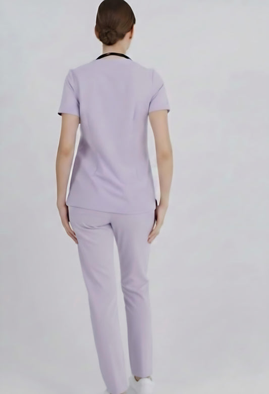 Person wearing a light purple scrub set on a white background