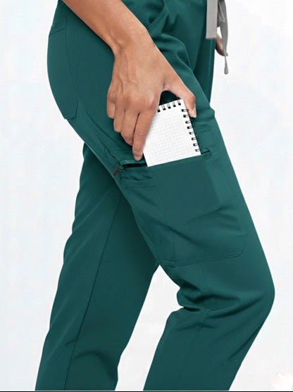 Green scrubs with a pocket holding a notepad on a white background