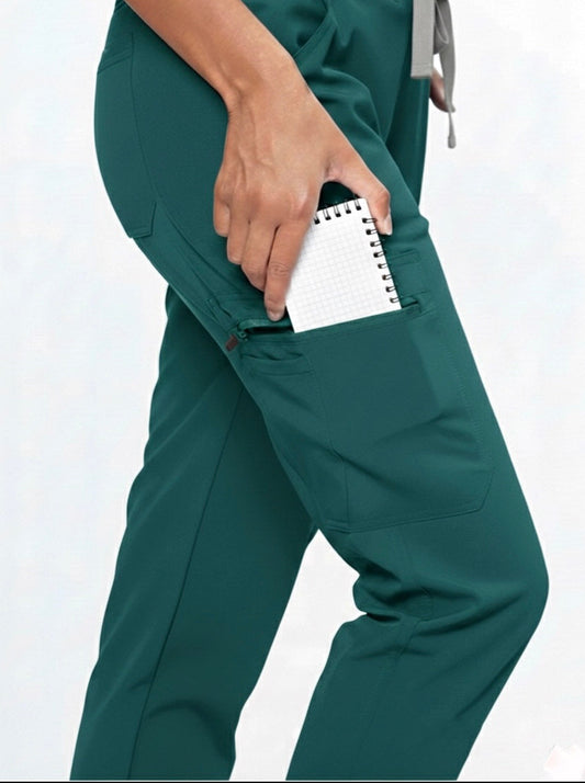 Green scrubs with a pocket holding a notepad on a white background